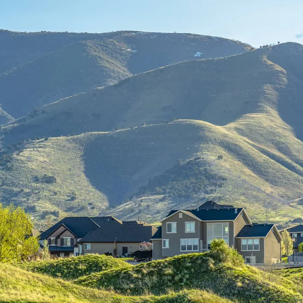 Čtvercové domy na úpatí hory pod jasným nebem za slunečného dne — Stock fotografie
