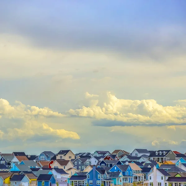 Quadro Quadrado Vista panorâmica de casas sob vasto céu cheio de nuvens inchadas iluminadas — Fotografia de Stock