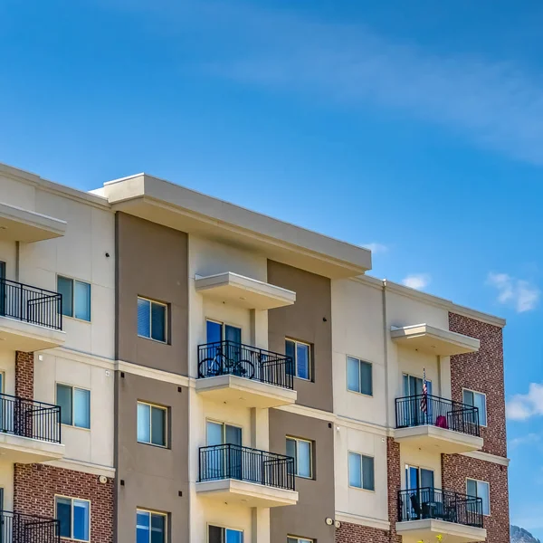 Plaza Sereno cielo azul con nubes hinchadas sobre un edificio residencial en un día soleado — Foto de Stock