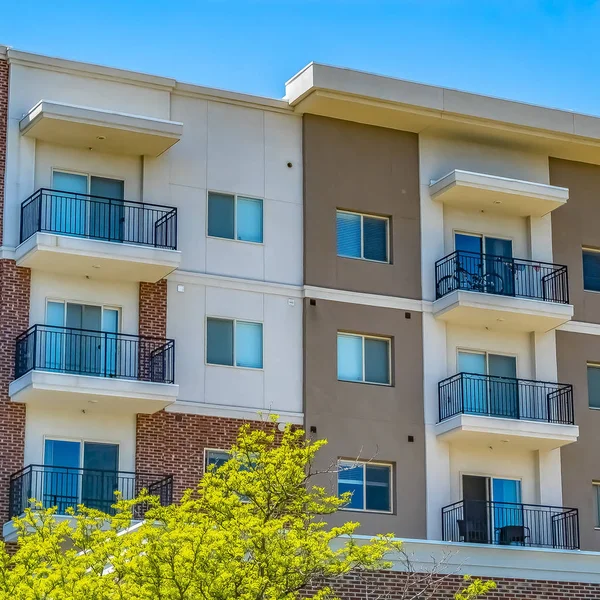 Square Residential building featuring red brick exterior wall and small balconies