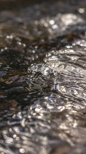 Panorama Acercamiento de un arroyo con agua congelada translúcida sobre rocas oscuras —  Fotos de Stock