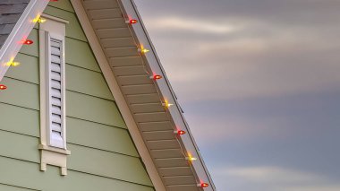 Panorama çerçevesi güneş batımında bulutlu gökyüzüne karşı renkli ışıklar ile gri çatı yakın