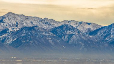 Panorama çerçevesi bulutlu gökyüzüne karşı çarpıcı bir dağın Panoraması, bulanık bir vadi üzerinde yükselen