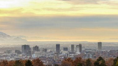 Panorama çerçeve Panoraması şehir Salt Lake City dağ ve bulutlu gökyüzüne karşı gün batımı