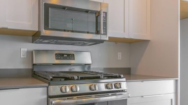 Panorama pişirme aralığı ve modern bir mutfak içinde duvara monte mikrodalga