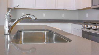Parlak musluk ve lavabo yakın görünümü ile yeni bir evin Panorama çerçevesi mutfak iç