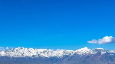 Panoramik manzara, kahverengi otlar ve güneş ışığı alan bir gölün ön planda