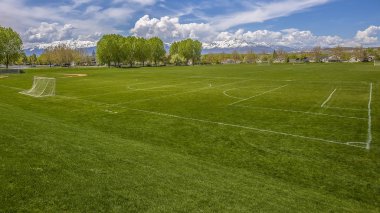 Panorama çerçeve futbol gol net ve bir çit arkasında beyzbol tribünde ile geniş spor alanı