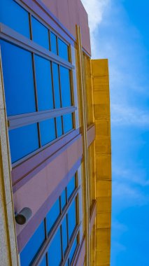 Panorama çerçevesi parlak mavi gökyüzüne karşı aşağıda görüntülenen ticari bir binanın dış