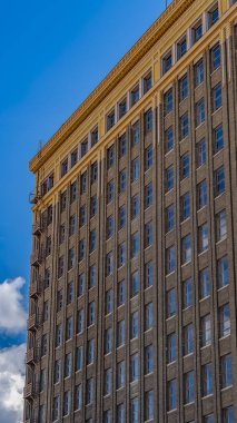 Panoraması cam pencerelere yansıyan bulutlu mavi gökyüzü ile bir binanın dış