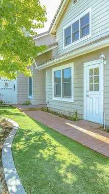 Panorama çerçevesi tuğla yolu ve güneşli bir günde görüntülenen zengin yeşil çim ile bir evin Backyard