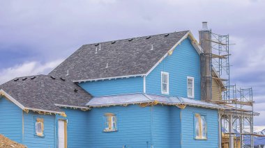 Dağ ve bulutlu gökyüzüne karşı İskeleler ile inşaat altında Panorama mavi ev