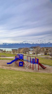 Panorama çerçevesi yemyeşil çim ve gölün yakınında güzel evlerin ortasında Park ve oyun alanı