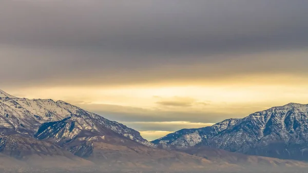 Panorama-Rahmenpanorama eines majestätischen, schneebedeckten und von Sonnenlicht beleuchteten Berges — Stockfoto