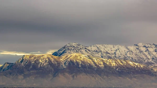 Panorama panoramatu majestátní hory pokryté sněhem a osvětleného slunečním zářením — Stock fotografie