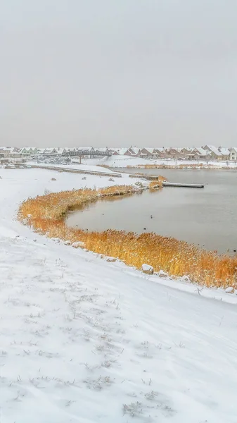 Marco panorámico Sendero cubierto de nieve con huellas a lo largo de un lago plateado en invierno — Foto de Stock