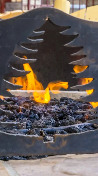 Panorama frame Close up of a black metal fire pit with an opening in the shape of a tree