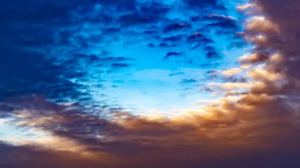 Panorama Vista desfocada de um vasto céu azul cheio de nuvens escuras inchadas ao pôr-do-sol — Fotografia de Stock