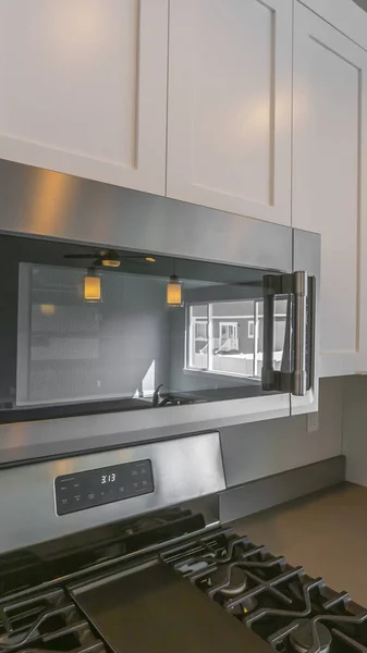 Ramka panoramiczna zbliżenie kuchenki mikrofalowej i drewnianych szafek zamontowanych na ścianie kuchni — Zdjęcie stockowe