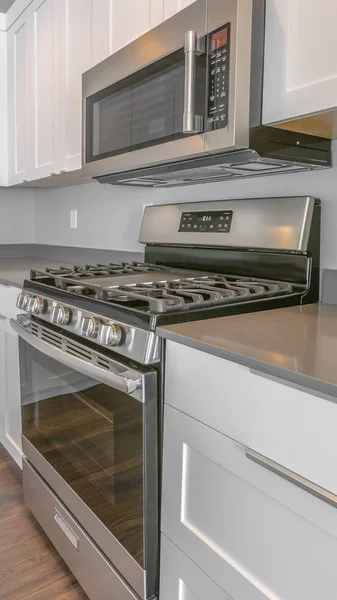 Panorama moderne kücheneinrichtung eines hauses mit glänzendem herd und wandmikrowelle — Stockfoto