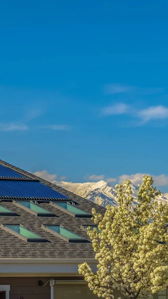 Panorama cadre Toit d'une maison avec panneaux solaires et puits de lumière vus par une journée ensoleillée — Photo