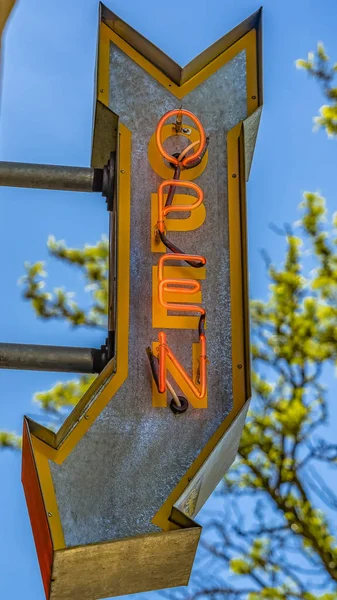 Panorama close up van een open pijl teken aan de buitenkant van een gebouw op een zonnige dag — Stockfoto