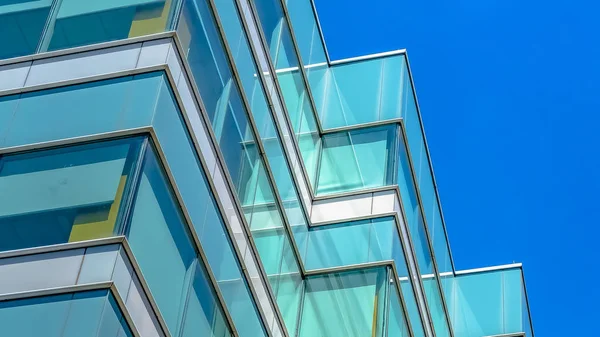 Panoramarahmen modernes Gebäude außen von unten betrachtet mit blauem Himmel im Hintergrund — Stockfoto