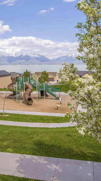 Panorama çerçevesi bulutlu mavi gökyüzü altında göl ve dağa karşı oyun ve evler