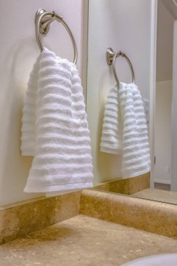 Bathroom interior with close up view of a white towel hanging on a towel ring clipart