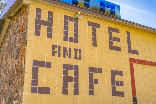 Énorme hôtel et café signe sur le mur extérieur d'un bâtiment avec des lumières extérieures — Photo