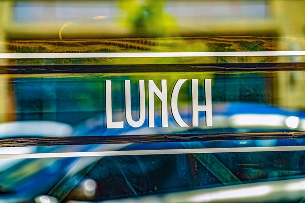 Vista de perto de um sinal de almoço contra a parede de vidro de um restaurante — Fotografia de Stock