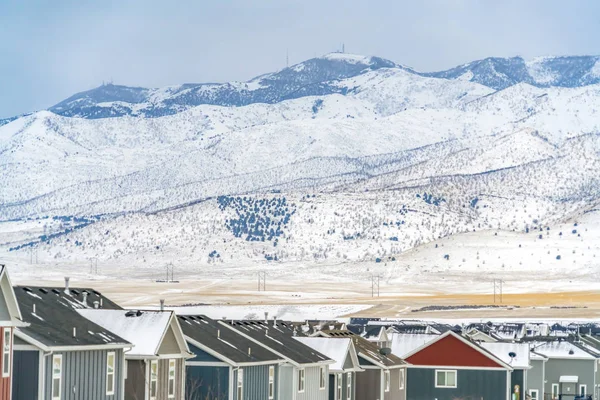 Exterior de las casas contra el cielo y la montaña cubierto de nieve en invierno — Foto de Stock