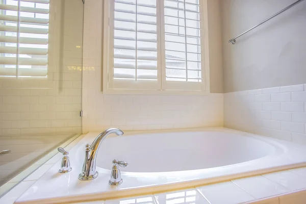 Interior del baño con bañera incorporada y toallero brillante en la pared blanca — Foto de Stock