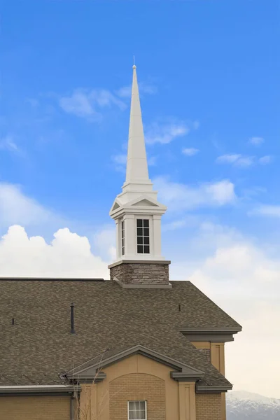 White steeple on top of the pitched roof of a church with brick exterior wall — Stock Photo, Image