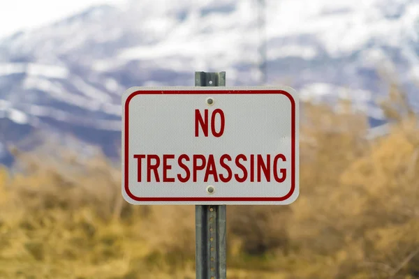 Close up of white sign board with the words No Trespasing painted in red color — Stock Photo, Image