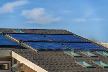 Güneş enerjili su ısıtıcı güneş panelleri ve tavan penceresi ile eğimli çatı
