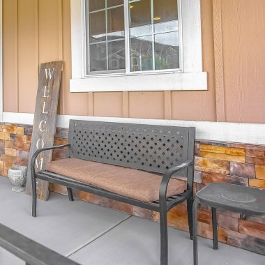 Bir evin sundurma bir pencerenin önünde kare Bench ve tabure