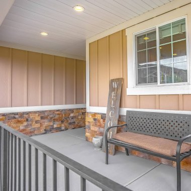 Bir evin sundurma bir pencerenin önünde kare kare tezgah ve tabure