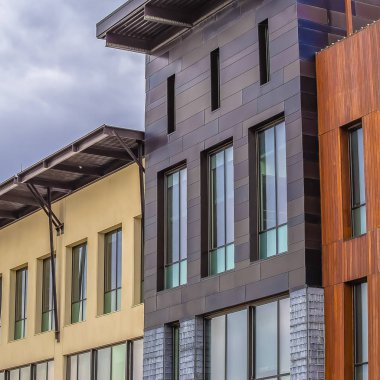 Kare kare kabarık gri bulutlar ile kaplı gökyüzüne karşı düz bir çatı ile bina dış