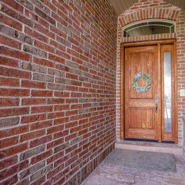 Kare çerçeve çelenk borda feneri ve kemerli vasistas pencere ile rustik ahşap kapı