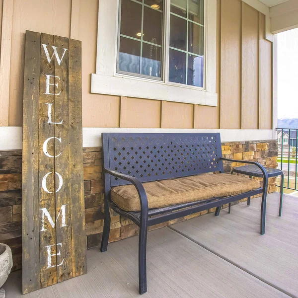 Square Furniture and Welcome sign on the porch of a home ovelooking mountain and sky