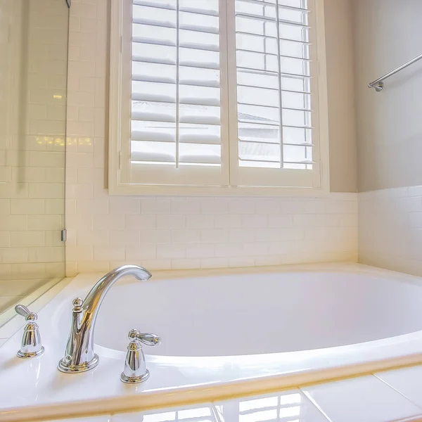 Kwadratowy łazienka wnętrze z wbudowaną wanną i błyszczącą ręcznik pręt na białej ścianie — Zdjęcie stockowe