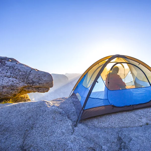 Man släpper ett tält i Yosemite på sunrise — Stockfoto