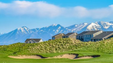 Karla kaplı dağa ve mavi gökyüzüne karşı bir tepede bulutlarla panorama residences