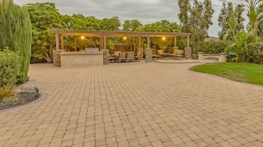 Panorama çerçeve Bir pavyon altında yangın çukuru ve yemek alanı ile Taş tuğla driveway ve veranda