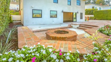 Aynı malzemeden yapılmış bir taş tuğla veranda ve sekizgen yangın çukuru ile Panorama House