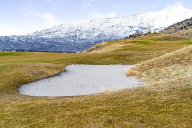 Kahverengi ve yeşil otlarla kaplı tepe arazisiüzerinde içi boş alan