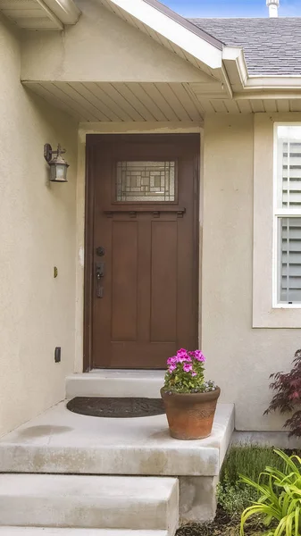 Fachada vertical de una casa con escaleras de hormigón que conduce a la puerta acristalada marrón — Foto de Stock