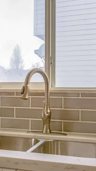 Vertical Double sink and faucet of a kitchen with view of outdoors through the window — Stock Photo, Image