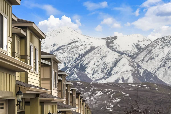 Σειρά από σπίτια με θέα ένα βουνό που έχει σκεπαστεί με χιόνι το χειμώνα — Φωτογραφία Αρχείου